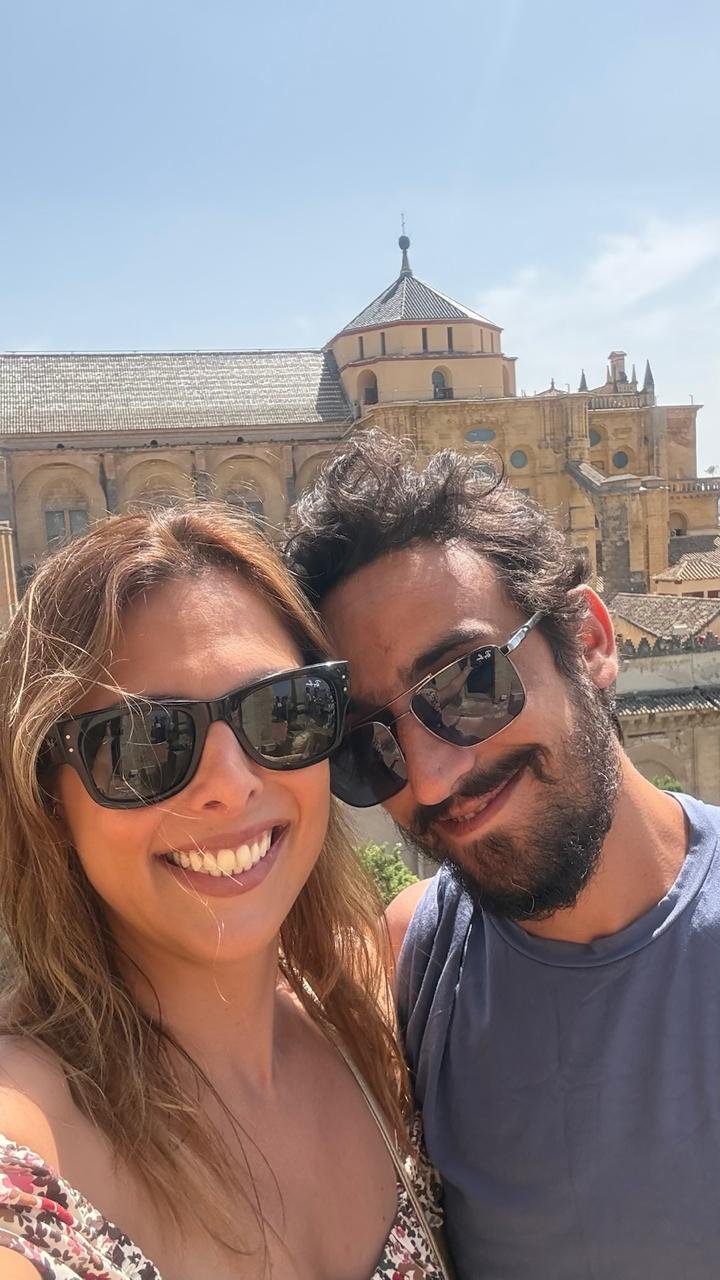 Karine e Diego sorrindo juntos em uma viagem